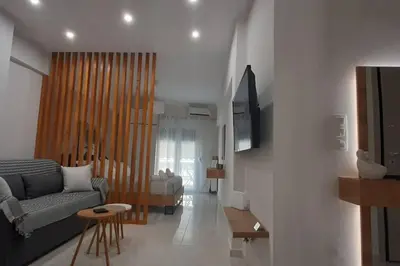 a living room with a couch and a tv in it at Α&J Sweet Home in Athens