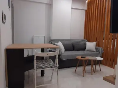 a living room with a couch and a table and chairs at Α&J Sweet Home in Athens