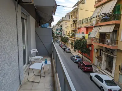 a balcony with a chair and a street with cars at Lavender-Emma cosy apartment near city center in Athens