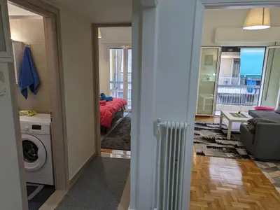a room with a living room with a couch and a washer at Lavender-Emma cosy apartment near city center in Athens