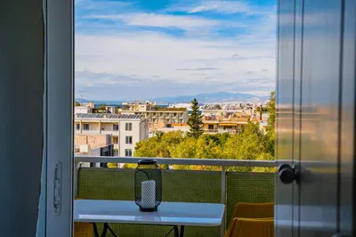 a table on a balcony with a view of a city at Blue vibes by Glyfada beach in Athens