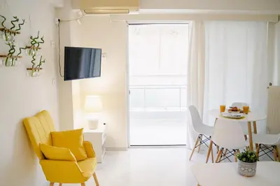 a living room with a yellow chair and a table at Blue vibes by Glyfada beach in Athens