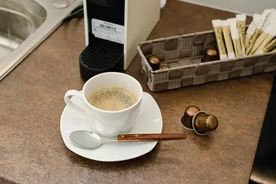 a cup of coffee on a plate with a spoon at Blue vibes by Glyfada beach in Athens
