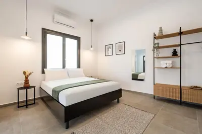 a white bedroom with a bed and a window at Ranny House in Athens