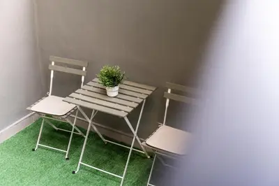 a wooden table with two chairs and a potted plant on it at Ranny House in Athens