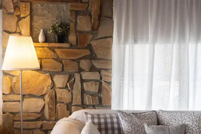 a living room with a couch and a stone wall at Sunny Loft with a Panoramic View in Athens