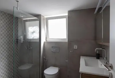 a bathroom with a toilet and a sink and a window at Private house - Garden - Glyfada in Athens