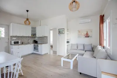 a white living room with a couch and a table at Private house - Garden - Glyfada in Athens