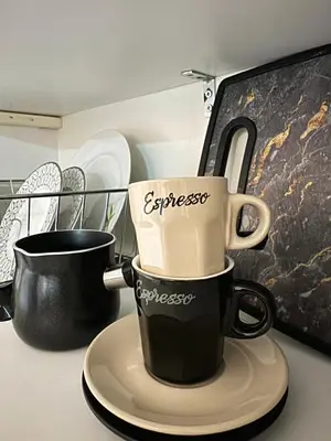 two coffee mugs sitting on a plate on a counter at Cozy home in Nea Smirni in Athens