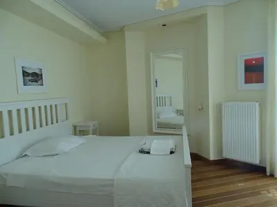 a bedroom with a large white bed and a mirror at Luxurious Family friendly Villa Anavyssos in Anavissos