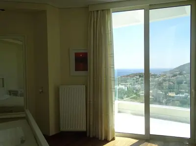 a bedroom with a large window with a view at Luxurious Family friendly Villa Anavyssos in Anavissos