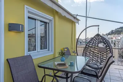 a balcony with a table and chairs and a window at Parthenon crown penthouse in Athens
