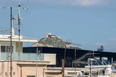 a mountain in the distance behind a building at Parthenon crown penthouse in Athens