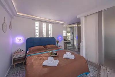 a bedroom with a blue bed with towels on it at Parthenon crown penthouse in Athens