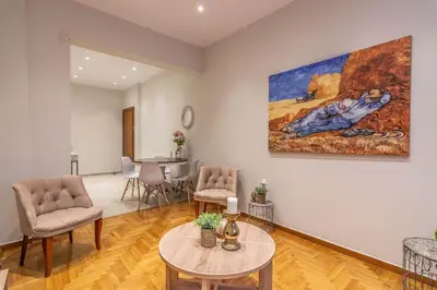 a living room with a table and chairs and a painting at Nebiolo in Athens