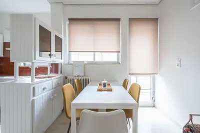 a white kitchen with a white table and chairs at Open -view Apartment, YGEIA Hospital in Athens