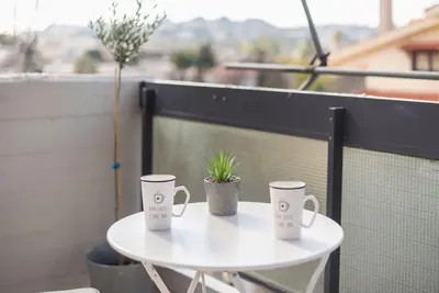 two coffee mugs sitting on a table on a balcony at Open -view Apartment, YGEIA Hospital in Athens