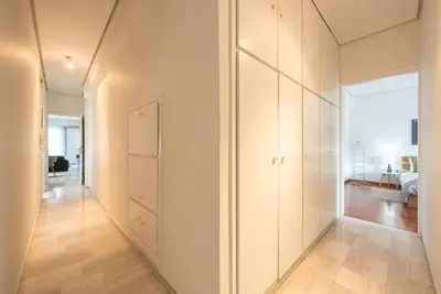 a hallway with white walls and wooden floors at Open -view Apartment, YGEIA Hospital in Athens