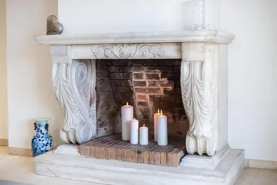 a fireplace with white candles in a room at Open -view Apartment, YGEIA Hospital in Athens
