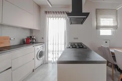 a kitchen with a stove top oven next to a dishwasher at Valeria's Sea View Apartment in Athens