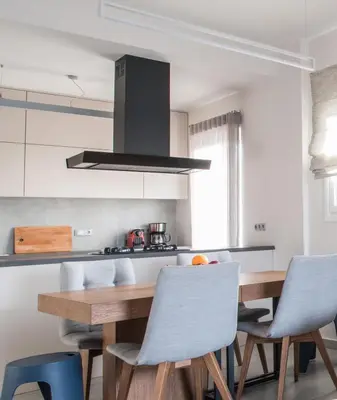 a kitchen with a wooden table and blue chairs at Valeria's Sea View Apartment in Athens