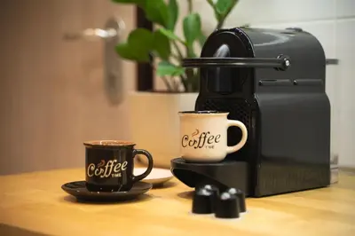 two coffee cups on a counter next to a coffee maker at E44 by SpitiSou in Athens