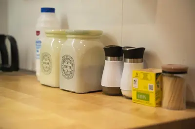 a group of four bottles of sauce and milk on a counter at E44 by SpitiSou in Athens