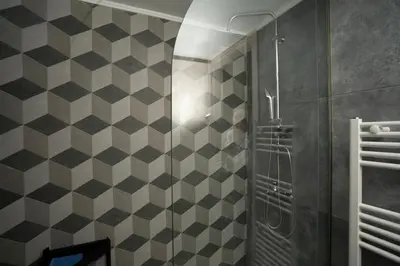 a bathroom with a shower with black and white tiles at E44 by SpitiSou in Athens