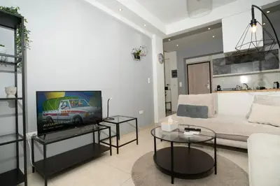 a living room with a couch and a tv at E44 by SpitiSou in Athens