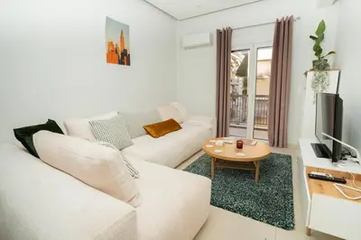 a living room with a white couch and a table at E9 by SpitiSou in Athens