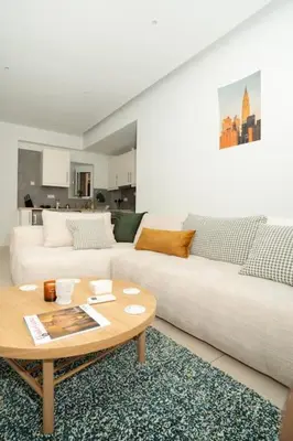 a living room with a white couch and a coffee table at E9 by SpitiSou in Athens