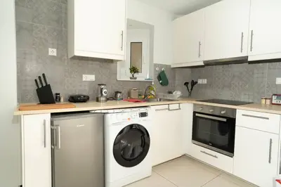 a white kitchen with a washing machine in it at E9 by SpitiSou in Athens