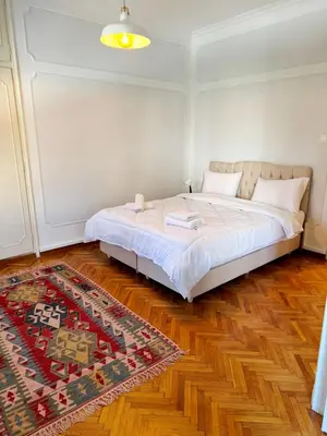 a bedroom with a bed in a room with a rug at Athenian Gate Residence to Plaka in Athens