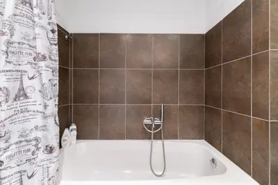 a bathroom with a bath tub with a shower curtain at Athenian Gate Residence to Plaka in Athens