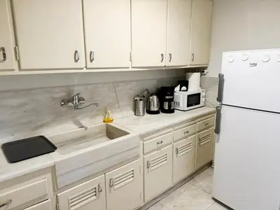 a kitchen with white cabinets and a white refrigerator at Athenian Gate Residence to Plaka in Athens