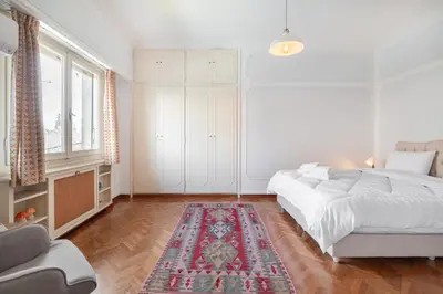 a bedroom with two beds and a rug at Athenian Gate Residence to Plaka in Athens
