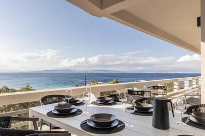 a dining room with a view of the ocean at Villa Vel Aegina in Vaia