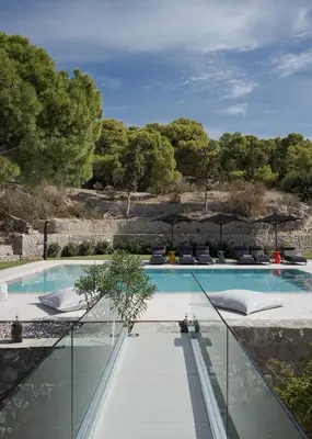 a swimming pool with glass walls and trees at Villa Vel Aegina in Vaia