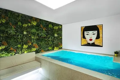 a swimming pool in a house with a painting on the wall at CITYLUXE Suites & Rooms in Athens