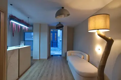 a living room with a white couch and a lamp at CITYLUXE Suites & Rooms in Athens