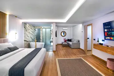 a bedroom with a large bed and a bath tub at CITYLUXE Suites & Rooms in Athens