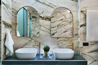 two sinks in a bathroom with two mirrors at CITYLUXE Suites & Rooms in Athens