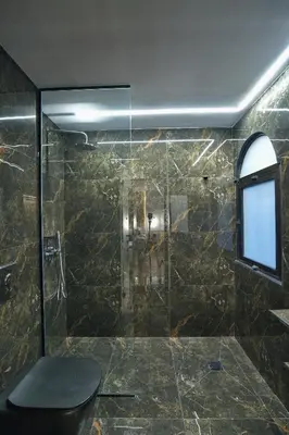 a bathroom with a shower with a toilet and a window at CITYLUXE Suites & Rooms in Athens