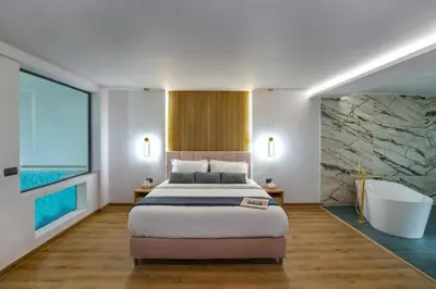 a bedroom with a large bed and a bath tub at CITYLUXE Suites & Rooms in Athens