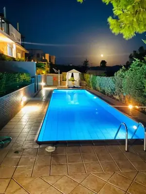 a swimming pool in a backyard at night at Villa Infinity View Athens Riviera in Anavissos