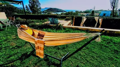 a hammock sitting on the grass in a yard at Villa Infinity View Athens Riviera in Anavissos