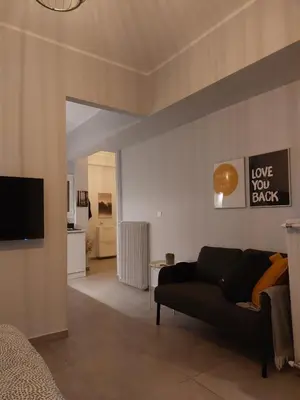a living room with a couch and a tv at Leo Athens Apartment Near Tram Station in Athens