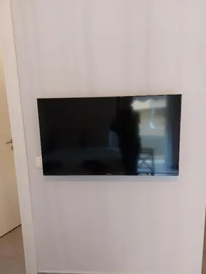 a flat screen tv on a white wall at Leo Athens Apartment Near Tram Station in Athens
