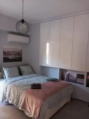 a bedroom with a large bed with white cabinets at Leo Athens Apartment Near Tram Station in Athens