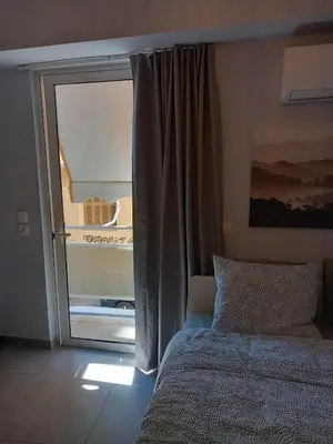 a bedroom with a bed and a sliding glass door at Leo Athens Apartment Near Tram Station in Athens